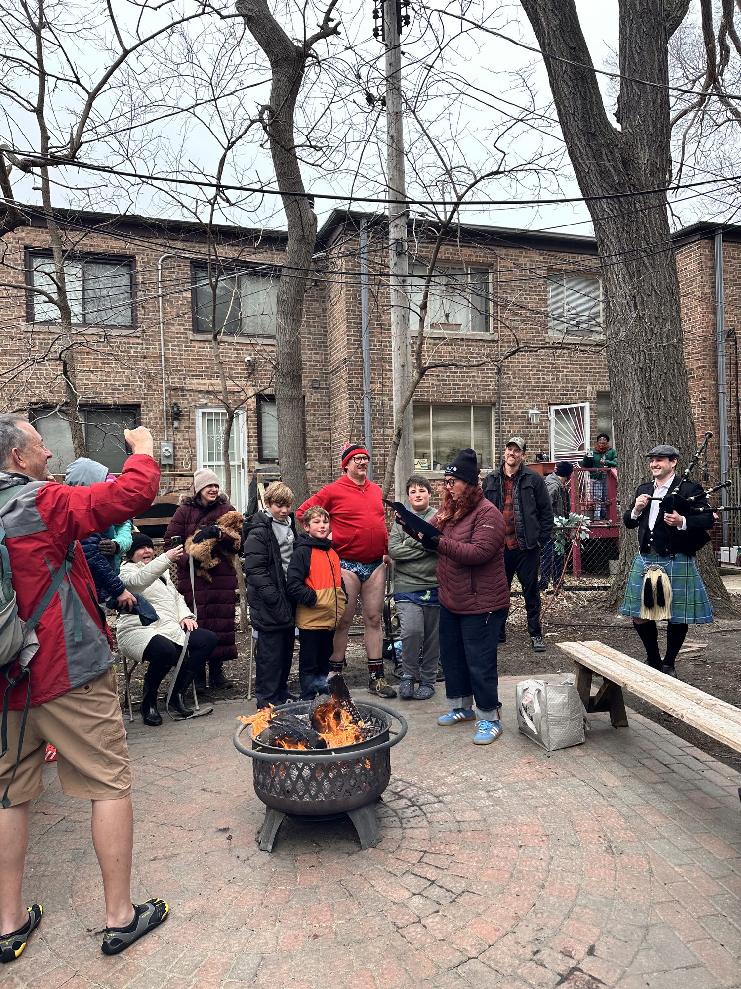Gathering around the bonfire with bagpiper